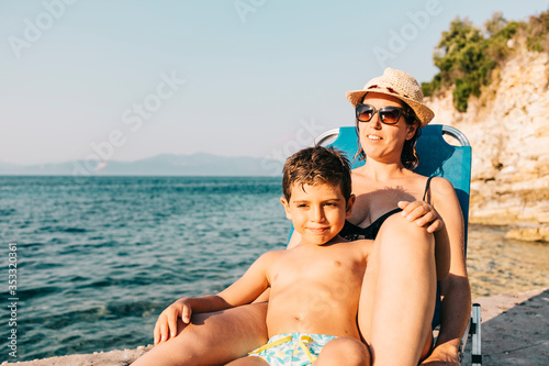 Mother and son relaxing on the coast near the sea