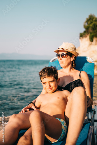 Mother and son relaxing on the coast near the sea