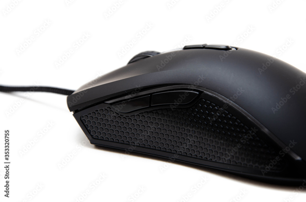 Black gaming mouse with side extra keys and a matte finish on white background. Mouse side view in macro and general plan. Lateral rubber inserts against sliding, pimples. Left and right mouse Black gaming mouse with side extra keys and a matte finish on white background. Mouse side view in macro and general plan. Lateral rubber inserts against sliding, pimples. Left and right mouse