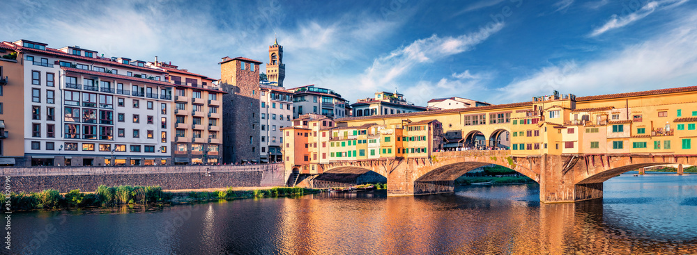 Panoramic summer view of medieval arched bridge with Roman origins - Ponte Vecchio over Arno river. Fabulous morning cityscape of Florence, Italy, Europe. Traveling concept background.