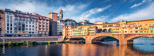 Panoramic summer view of medieval arched bridge with Roman origins - Ponte Vecchio over Arno river. Fabulous morning cityscape of Florence, Italy, Europe. Traveling concept background.