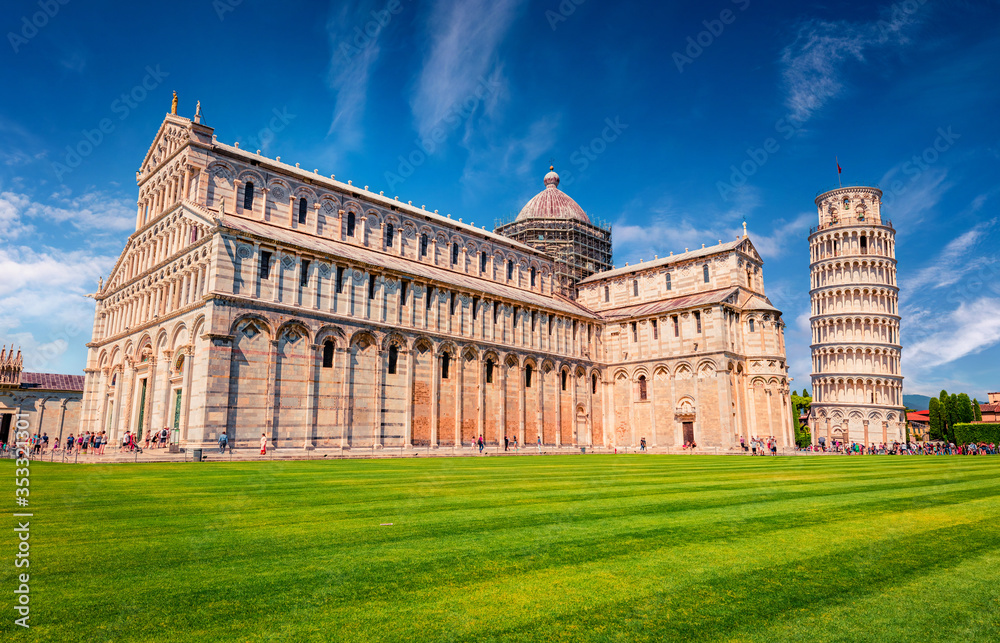 Attractive summer view of famous Leaning Tower in Pisa. Sunny morning scene with hundreds of tourists in Piazza dei Miracoli (Square of Miracles), Italy, Europe. Traveling concept background.