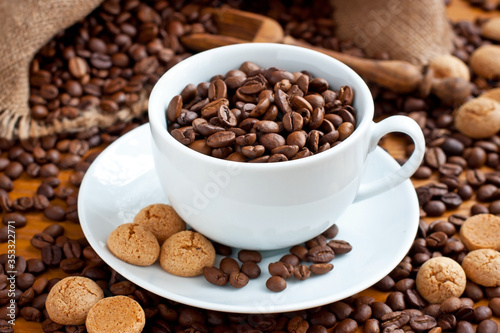 Composition with coffee cup and tasty almond cookies on wooden background