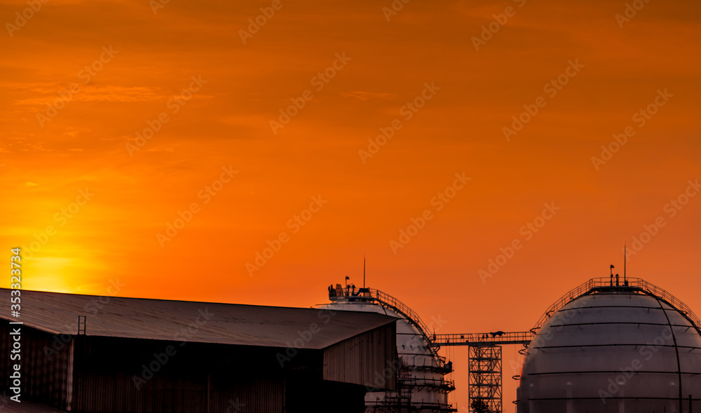 Industrial gas storage tank. LNG or liquefied natural gas storage tank. Red and orange sunset sky. Spherical gas tank in petroleum refinery. Above-ground storage tank. Natural gas storage industry. Industrial gas storage tank. LNG or liquefied natural gas storage tank. Red and orange sunset sky. Spherical gas tank in petroleum refinery. Above-ground storage tank. Natural gas storage industry.