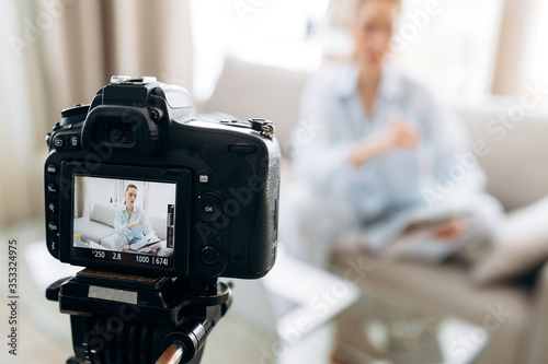 Photography Close-up photo of camera on which a teacher records an online learning course for her video blog sitting on sofa at home