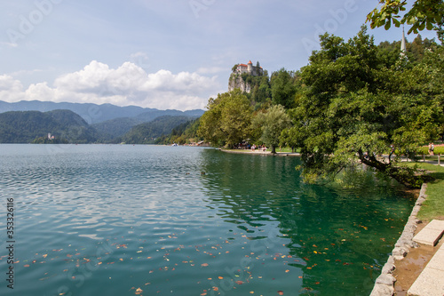 Lake Bled with a small Bled castle on the Rock surrounded by mountains covered with green forest. Slovenia, Bled.