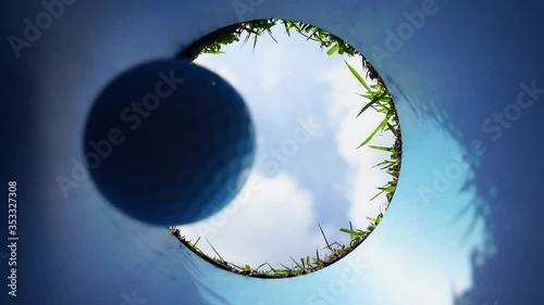 Hole in one successful putt. Golf ball going down hole with blue sky.  photo