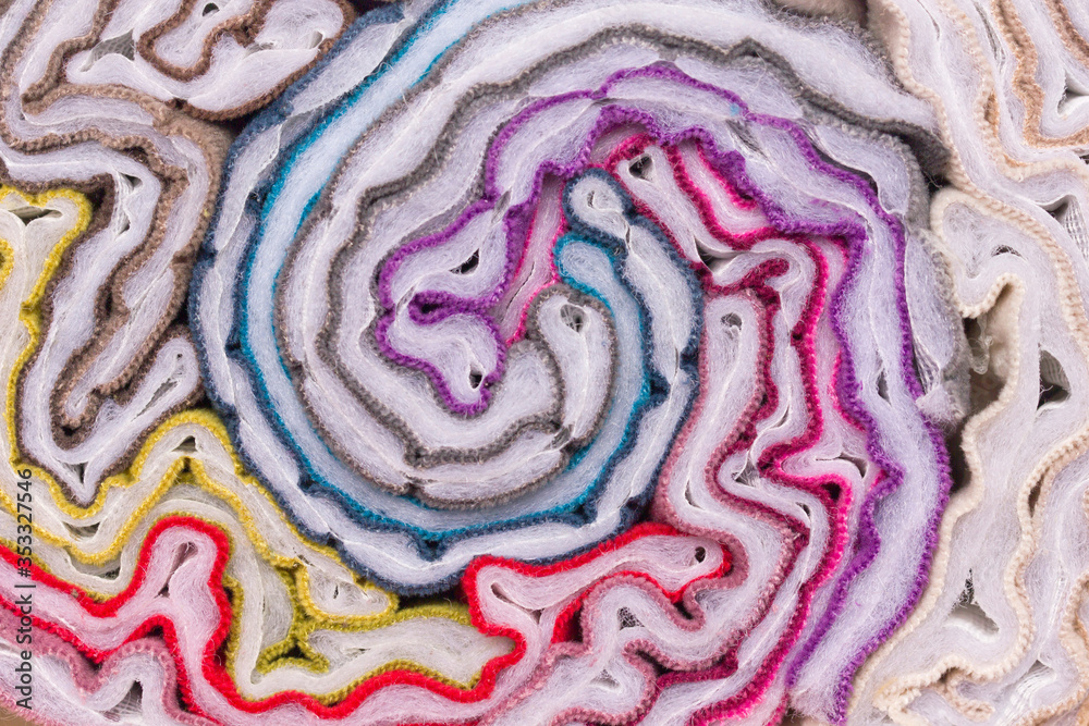 Obraz premium Twisted pieces of multi-colored fabric. Samples of furniture fabric in a roll. Abstract background from bright fabrics.