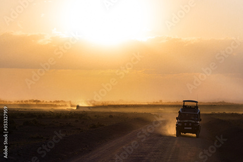 Sunset in african savannah, silhouettes of safari car and animals, Africa, Kenya, Amboseli national park 