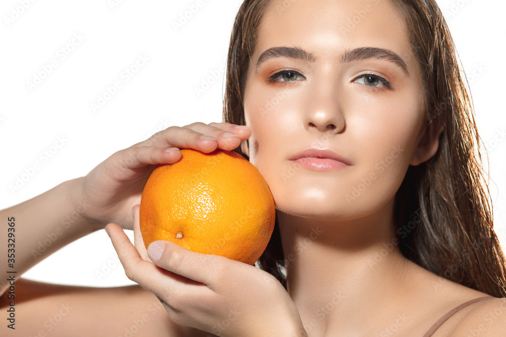 Touch. Close up of beautiful young woman with orange on white background. Concept of cosmetics, makeup, natural and eco treatment, skin care. Shiny and healthy skin, fashion, healthcare. Touch. Close up of beautiful young woman with orange on white background. Concept of cosmetics, makeup, natural and eco treatment, skin care. Shiny and healthy skin, fashion, healthcare.