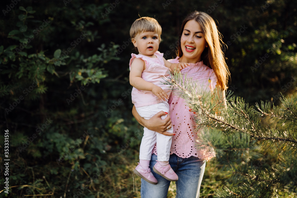 Young mother with her adorable little baby in forest Young mother with her adorable little baby in forest