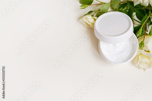 cosmetic cream for face and rose on light background, top view. Beauty, skin or body care concept