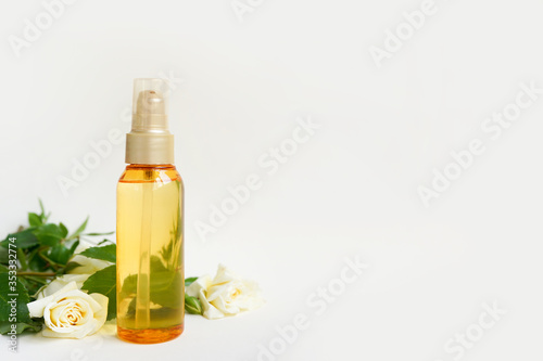 Bottle of essential aromatic oils and fresh flowers