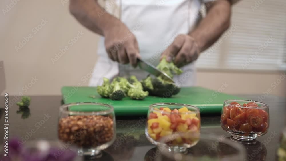 Chef cutting broccoli with knife in kitchen. Professional cutting of broccoli. Slicing of broccoli. Chef cutting broccoli with knife in kitchen. Professional cutting of broccoli. Slicing of broccoli.