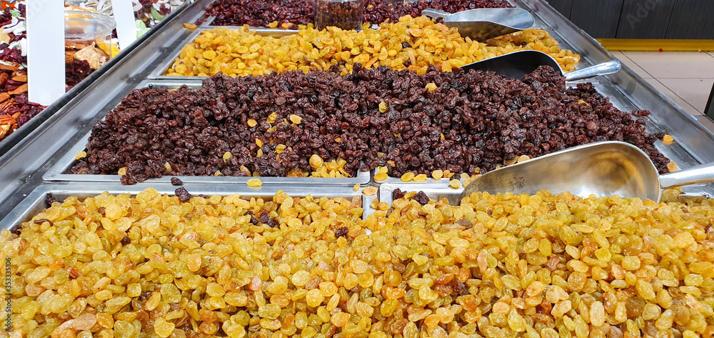Green and brown raisins in boxes for sale at market background Green and brown raisins in boxes for sale at market background