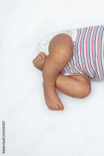 Crossed legs of infant on a white background © Tejjas