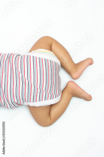 Infant legs over head photo lying on his chest © Tejjas