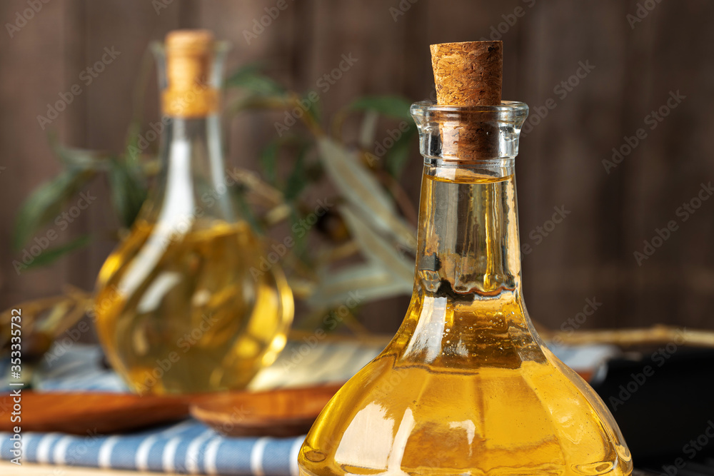 Olive oil bottle on wooden table, close up. Olive oil bottle on wooden table, close up.