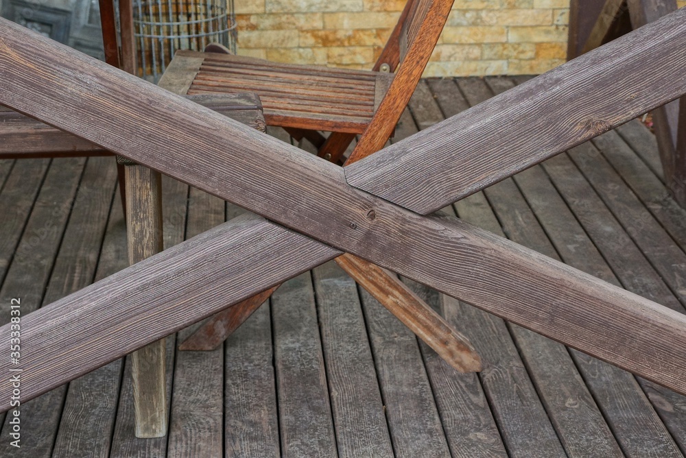 part of the fence from brown wooden boards in the cross on the street