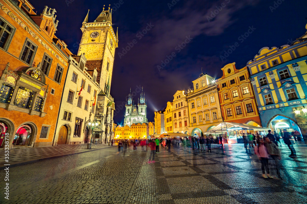 Many of tourists walking in spring night on the Old Town square with Tyn Church. Spectacular evening  sityscape of capital of Czech Republic - Prague, Europe. Traveling concept background..