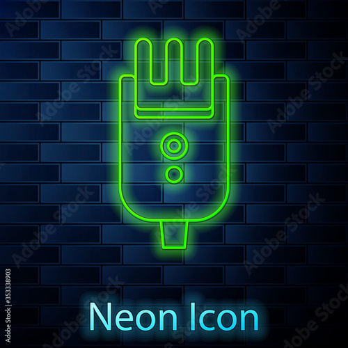 Glowing neon line Electrical hair clipper or shaver icon isolated on brick wall background. Barbershop symbol. Vector Illustration.