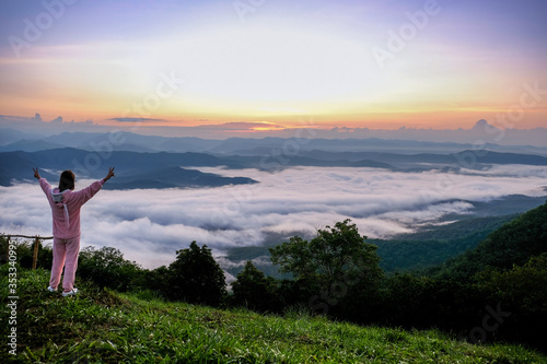 October,2019 Backside of asian girl wore pink Clothes standing on the mountain for looking landscape foggy view at Mon Kieng Dow, Nan province Thailand.