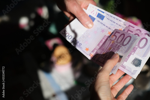 close-up of two female hands transferring 500 euro notes from on to the other