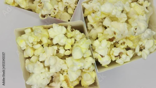 Popcorn in paper bags rotates on a white background