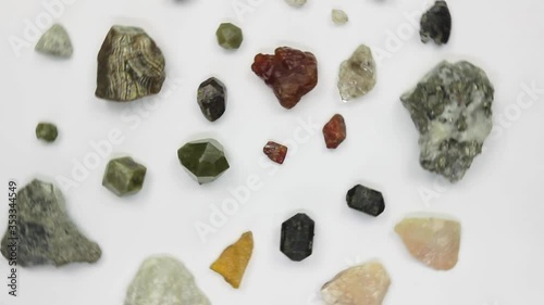 Various minerals, crystals, semiprecious stones rotating on a white background
