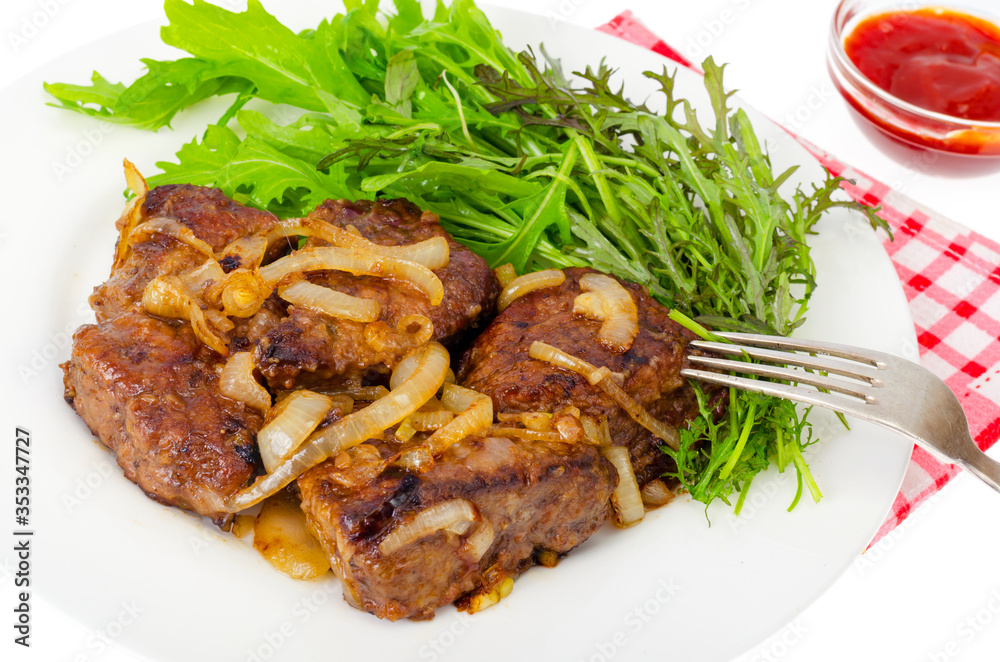 Pieces of fried liver with onions, fresh leaves of salads Pieces of fried liver with onions, fresh leaves of salads