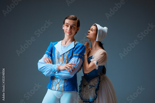 Young and graceful ballet dancers as Cindrella fairytail characters on studio background. Art, motion, action, flexibility, inspiration concept. Flexible caucasian ballet dancers in inspired dancing. photo