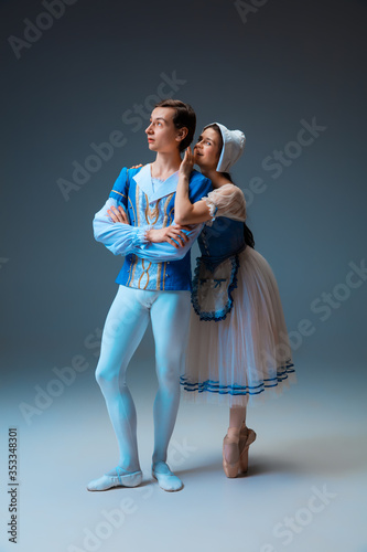 Young and graceful ballet dancers as Cindrella fairytail characters on studio background. Art, motion, action, flexibility, inspiration concept. Flexible caucasian ballet dancers in inspired dancing. photo