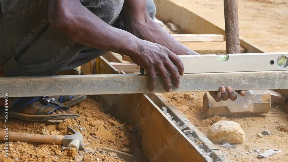 Male indian hands checks levels for accuracy during building wooden floor. Unrecognizable local builder works on construction area. Concept of future project. Close up Slow motion
