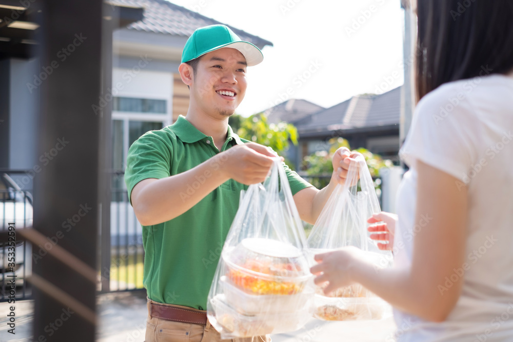 Food Delivery man wearing mask handing plastic bags shopping online from supermarket to female client service customer front house, express grocery when coronavirus covid19 new normal lifestyle. Food Delivery man wearing mask handing plastic bags shopping online from supermarket to female client service customer front house, express grocery when coronavirus covid19 new normal lifestyle.