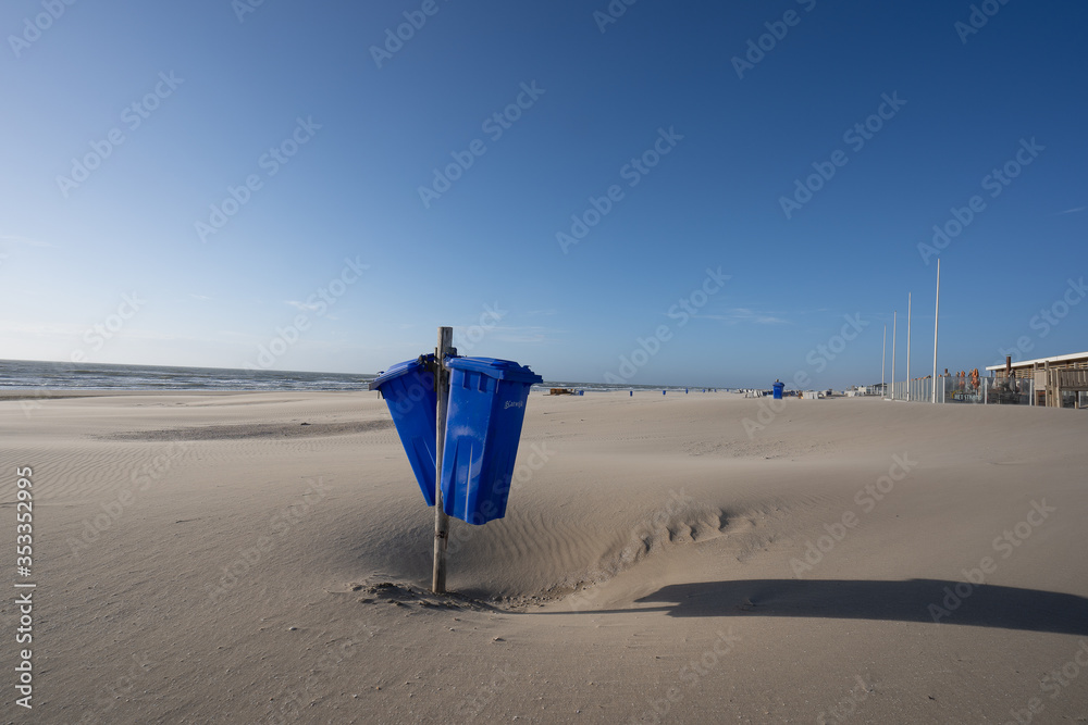 Blue trash cans dustbin on an empty beach Blue trash cans dustbin on an empty beach