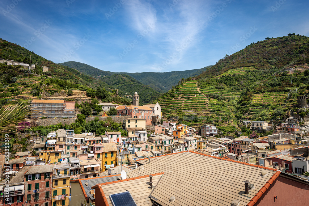 Cityscape of the ancient village of Vernazza and the terraced fields, green vineyards. Cinque Terre, National park in Liguria, La Spezia province, Italy, Europe. UNESCO world heritage site