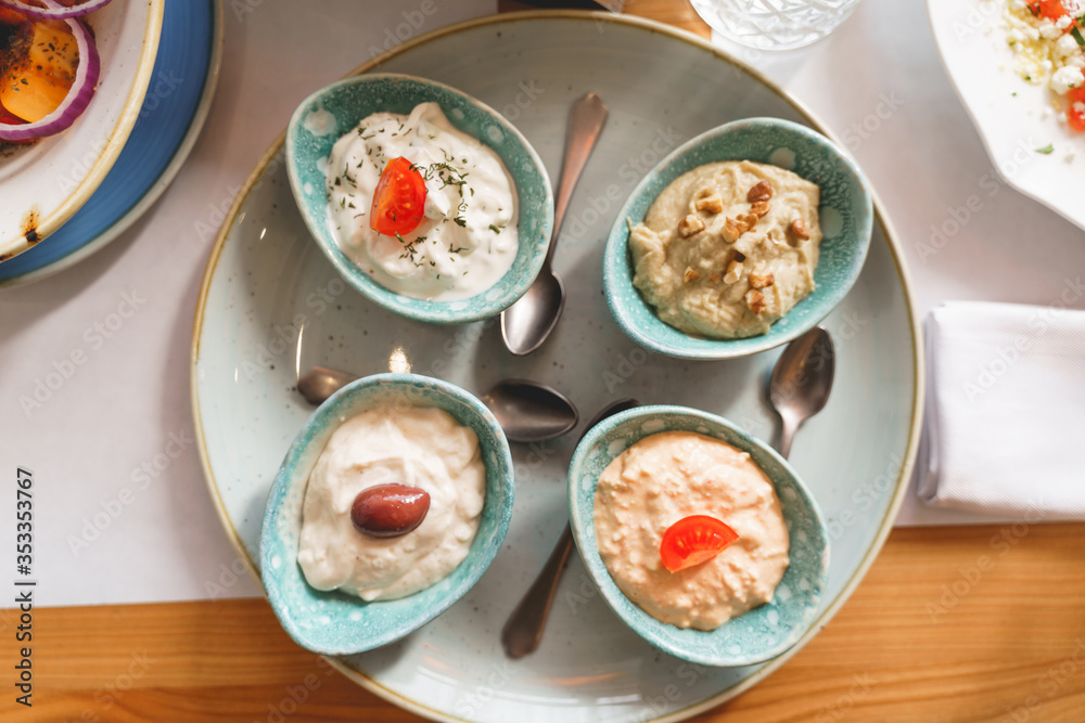 Delicious sauces and teaspoons on plate in cafe Delicious sauces and teaspoons on plate in cafe