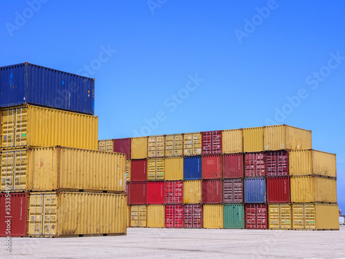 Shipping Containers in various colors stacked at a holding platform. photo