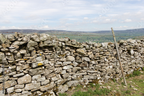 dry stacked stone wall with the hills of the Yorkshire Dales United Kingdom in the background