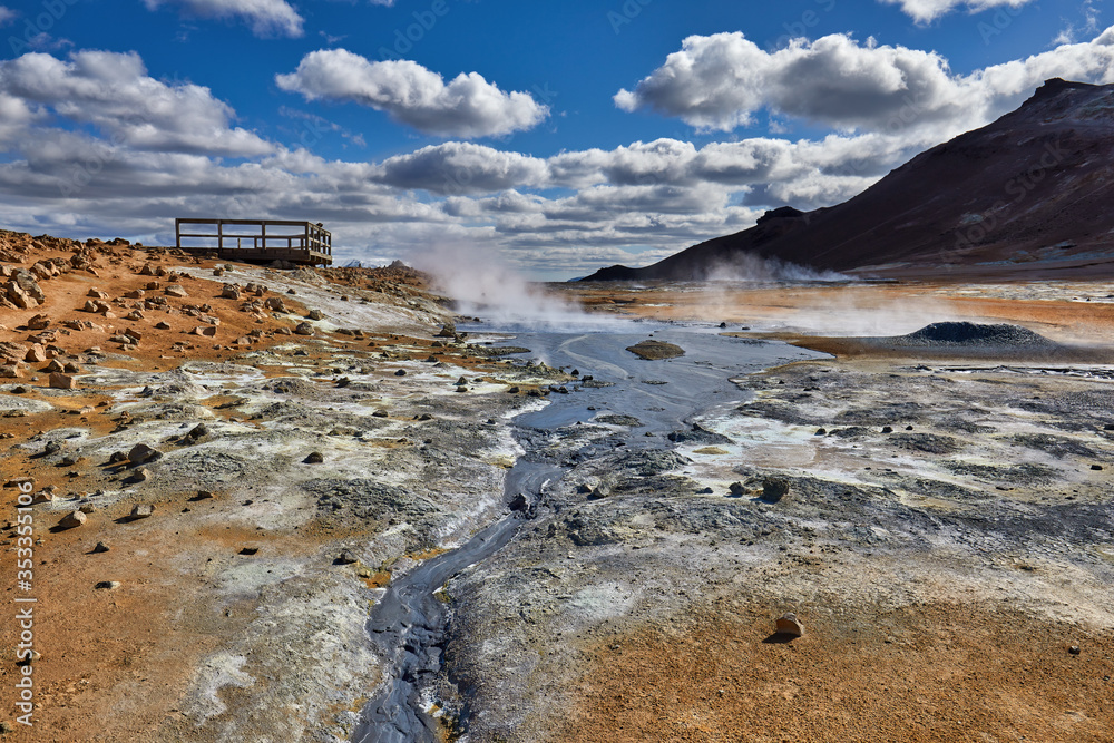 Natural steam rising from volcanic vents in the earth. Namafjall - geothermal area in field of Hverir. Landscape which pools of boiling mud and hot springs. Tourism and natural attractions in Iceland.