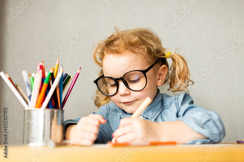 Cute European girl sits at school desk, concept of learning, back to school