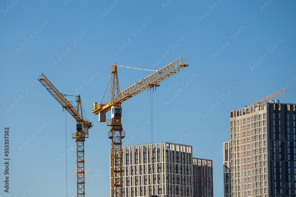 Construction site with cranes against the blue sky Construction site with cranes against the blue sky