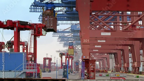 Gantry cranes are loading a container ship in the port of Hamburg / Germany. Two scenes - container are lifted up and placed on a ship photo
