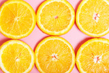 Fruit background made from slices of orange on a pink background. The concept of healthy food, vitamin C. Top view