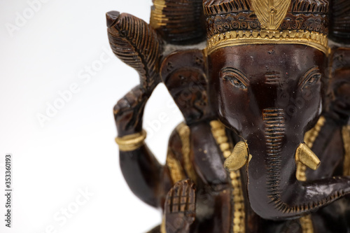 A wooden statuette of the Hindu deity Ganesh on a white background