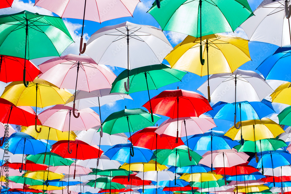 Multicolored umbrellas on blue sky background