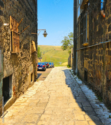 Foto narrow street between old buildnigs and beautiful view on green hills around sm