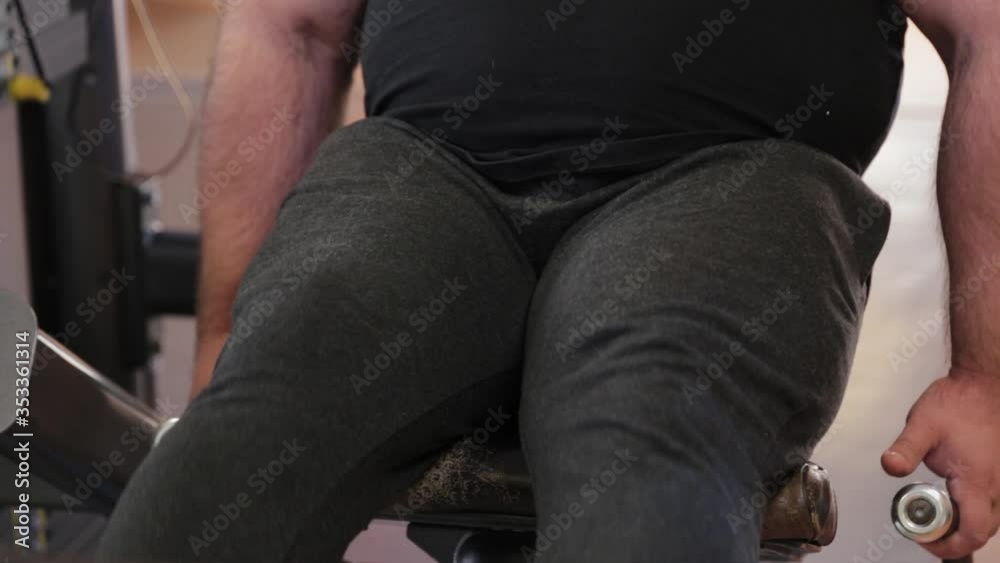 Very large bearded bodybuilder trains legs in the gym. Very large bearded bodybuilder trains legs in the gym.