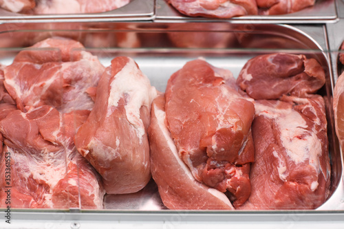 Heap of fresh meat food meat food background in supermarket store. Different types of raw meat in plastic boxes, leg of lamb on the bone, beef tail, beef neck, beef blade. Concept of farm and raw