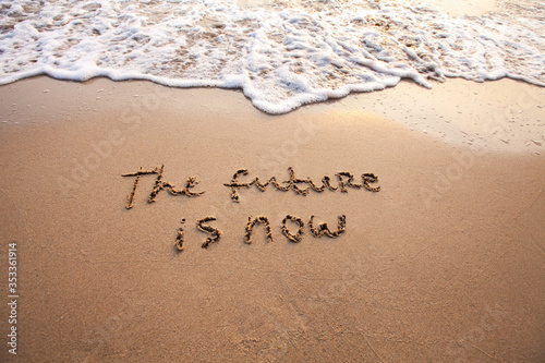 the future is now, innovative technology concept text written on sand photo